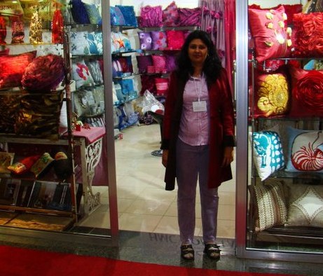 Seema, founder of HomeDecorTrends, at our showroom surrounded by handmade pillow covers.