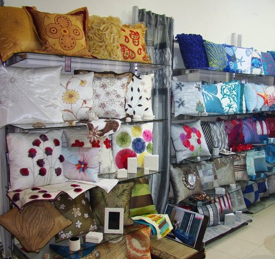 A wall of handmade pillow covers in different textures, colours and shapes.